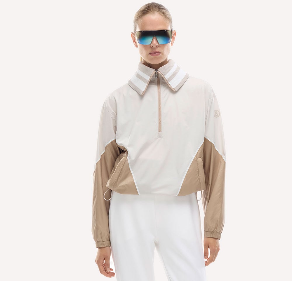 The Betty functional jacket in beige and camel with a short zip looks stylish on the female model, thanks to the drawstring at the waist.