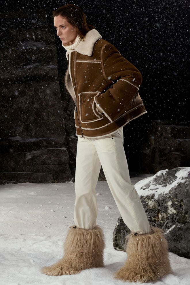 Ein weiteres Highlight: die kurze braune Veloursleder-Jacke mit Lammfellbesatz, getragen mit Steghose und Winter-Boots.