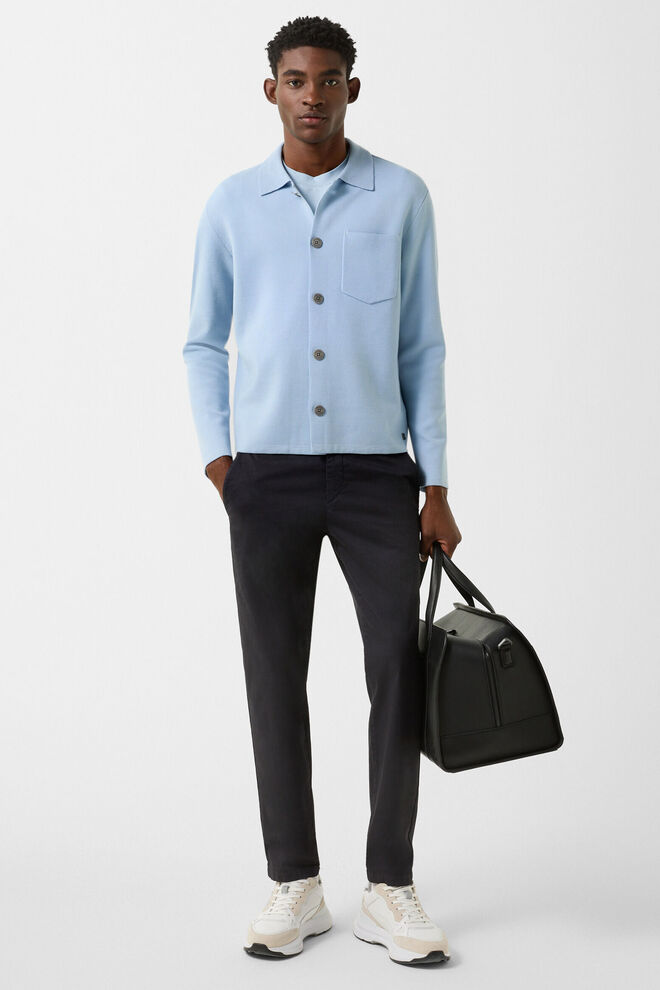 Das Herren Model tr&auml;gt Strickjacke Olaf in Hellblau, dazu Chino Riley in Anthrazit und eine Weekender Bag.