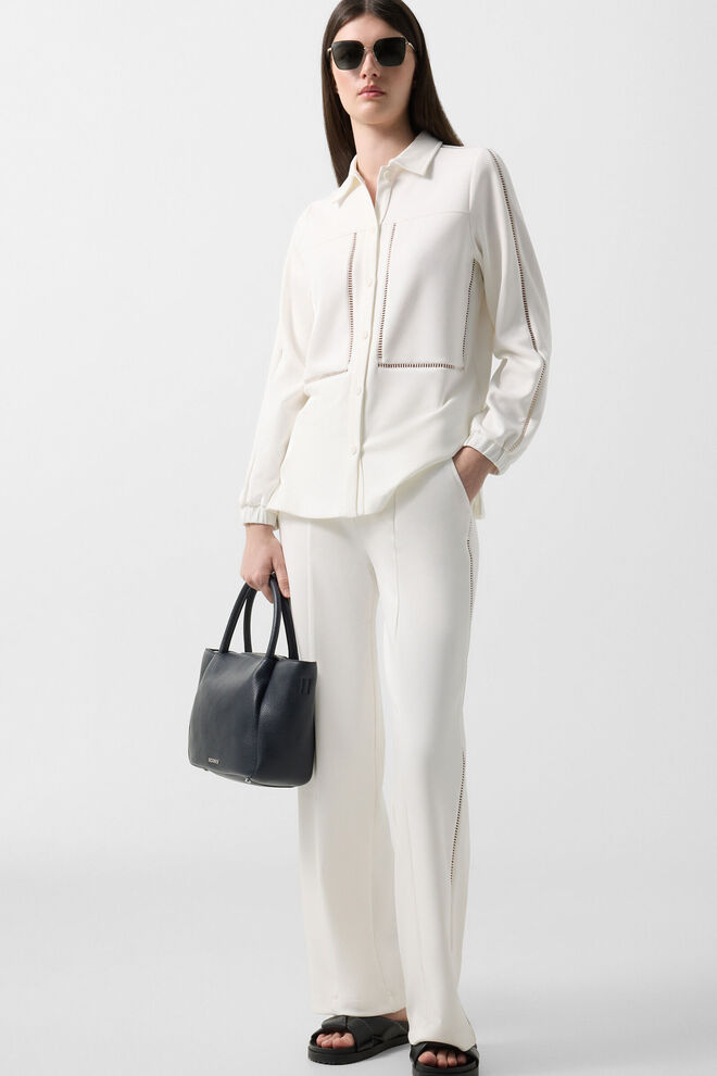 Das Damen Model tr&auml;gt einen Komplettlook bestehend aus einem Overshirt und Sweatpants mit Broderie Anglaise Details.