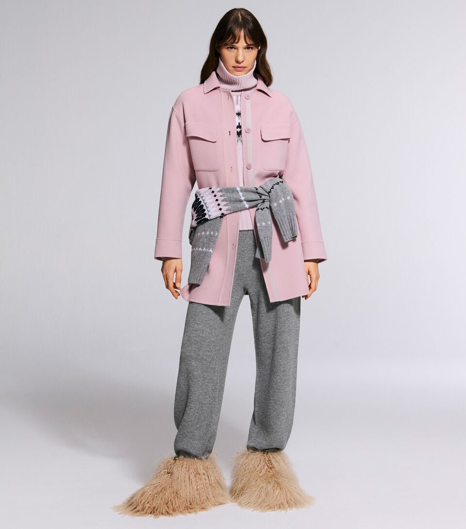The model is wearing the Tory double-faced jacket in ros&eacute; over the Luana trousers and the Ingrid pullover.