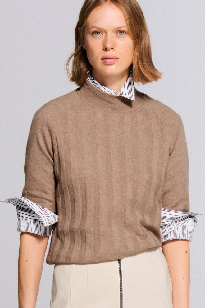 The other female model is wearing the Gigi striped shirt blouse, under the camel-colored Tina knitted top with a linear design.