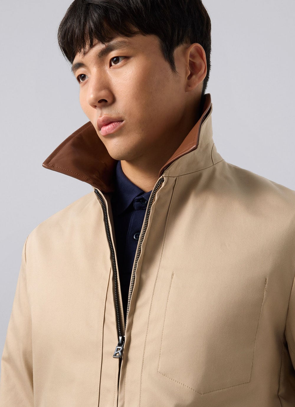 Close-up of the Mirco jacket in navy with an exclusive leather collar, worn over the Ouri half-zip pullover and Timo polo shirt.