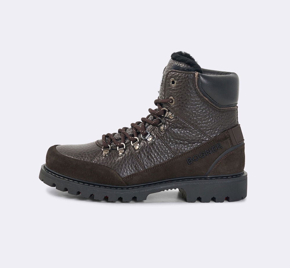 The dark brown Helsinki lace-up boots are crafted from leather and feature suede inserts, shearling details and fold-out spikes.