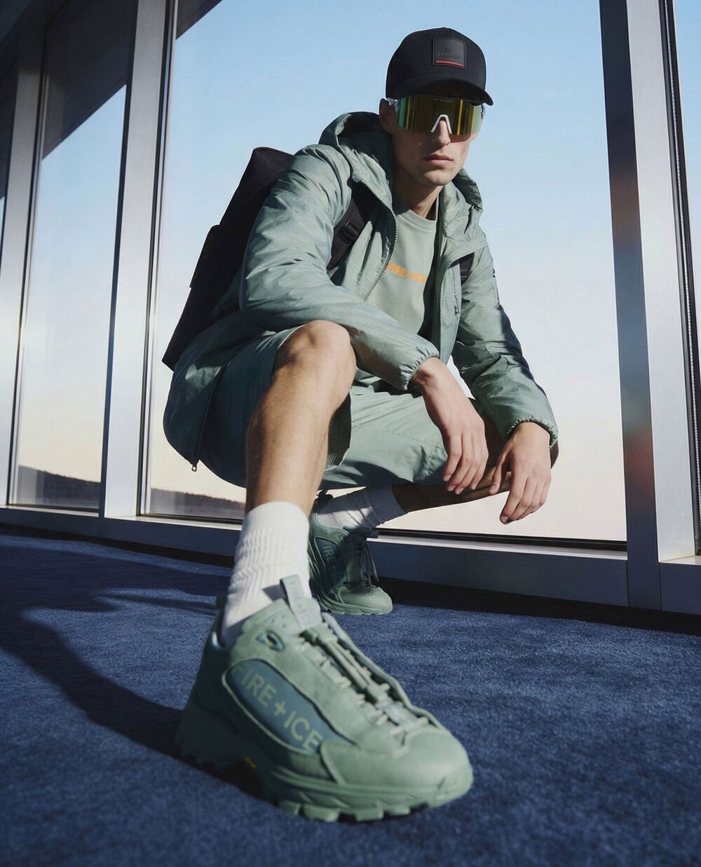 The male model, who is crouching down, is wearing an outfit in eucalyptus and the Montana trainers.