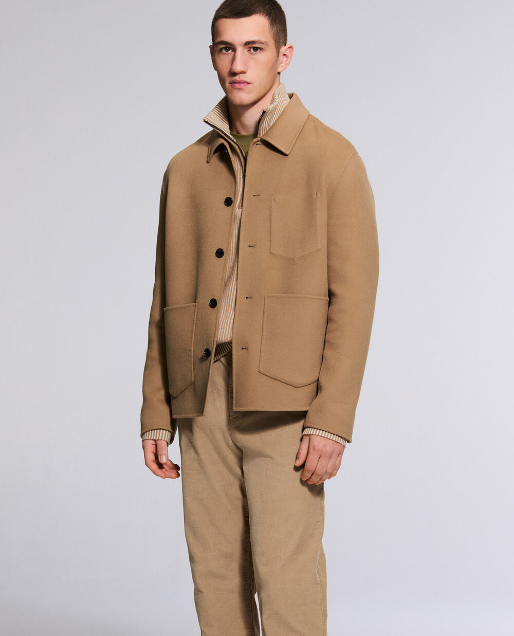 The model is wearing the Mirco double-faced jacket with colour-coordinating Travis trousers.