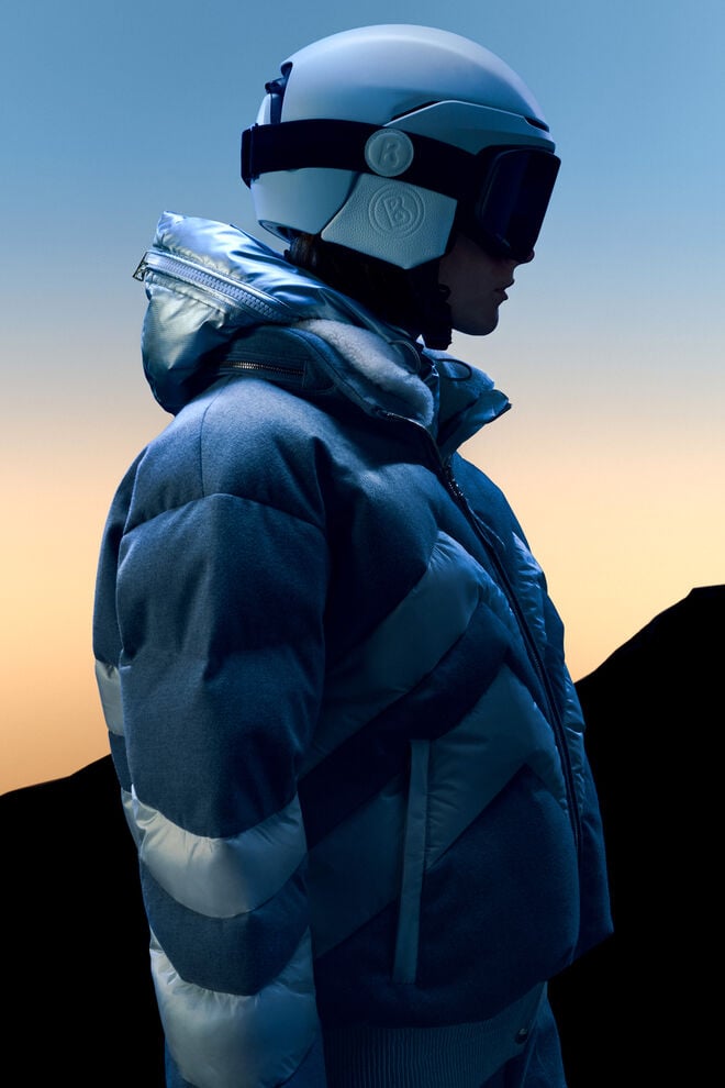 The Valea ski jacket stands out with its W motif and material blend. It is shown against the background of sunset on the slopes.