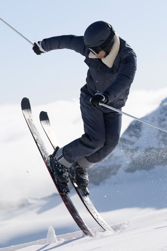 The image shows a model on skis, pairing the Jett denim ski pants with the Dena denim ski jacket.