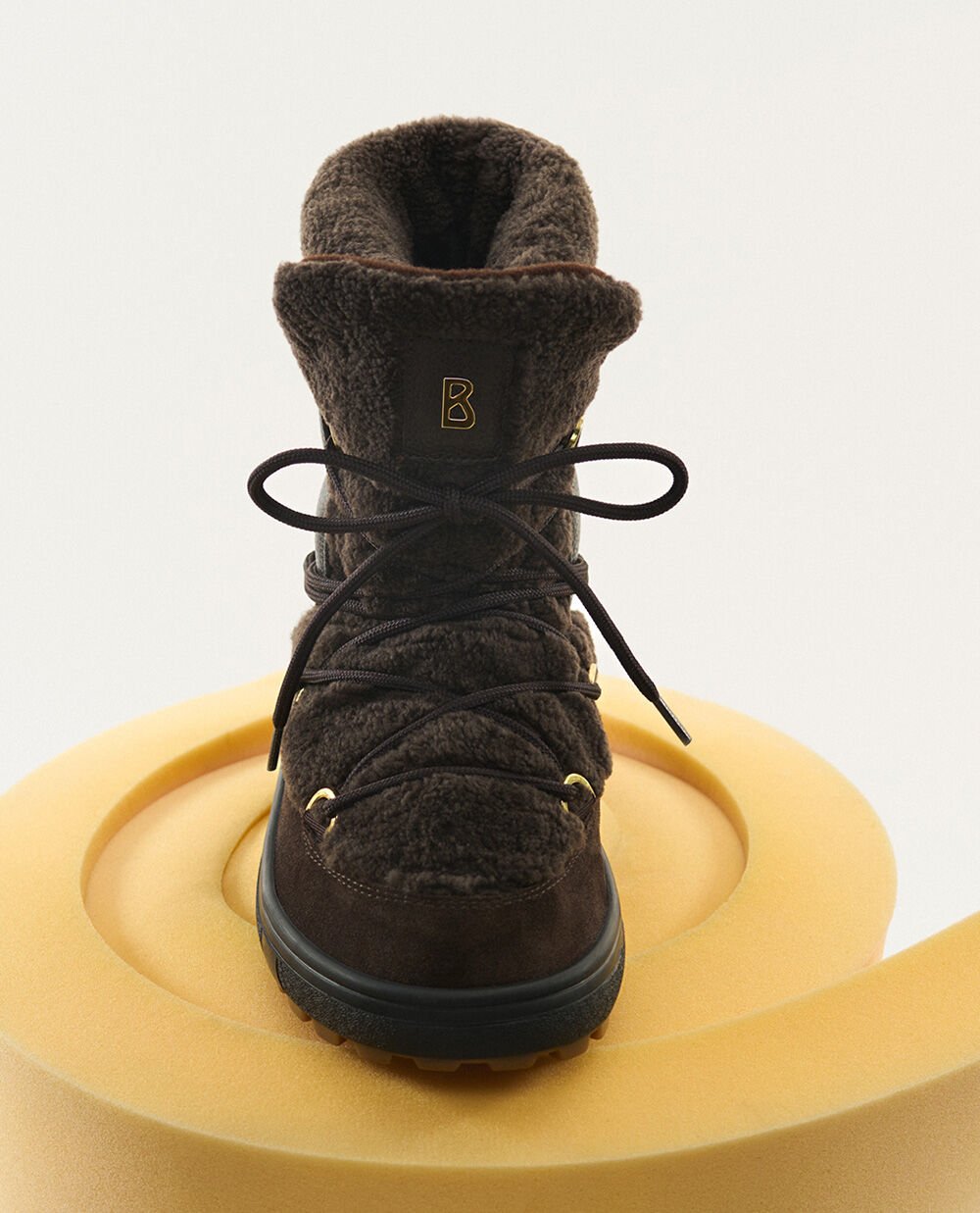 The brown boots are lined with shearling on the inside and outside and can be fastened with laces.