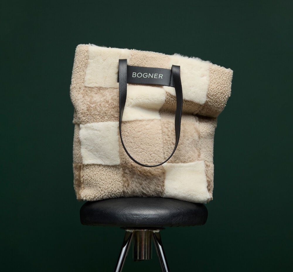 Posé sur une chaise en cuir, ce cabas se démarque par un motif patchwork unique de peau d’agneau aux teintes variées.