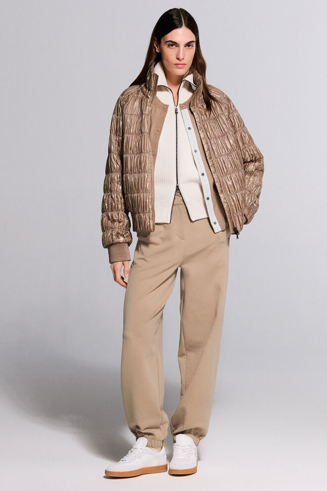 The female model is wearing the Jana knit jacket in cream and the Tanja cardigan in camel under the matching Sherry jacket with quilted stripes.