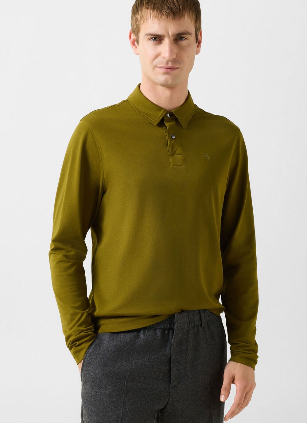 The male model is wearing the Timon polo long-sleeved shirt in olive green.