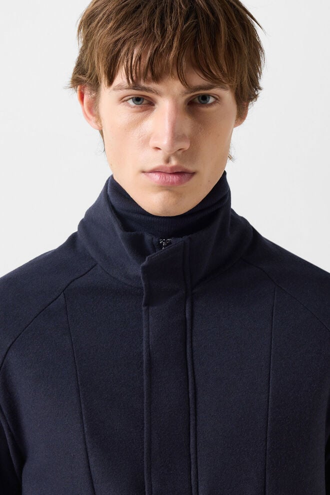 Le mannequin homme porte la veste Bradley en flanelle bleu marine sur le pull Gordon assorti en laine vierge.