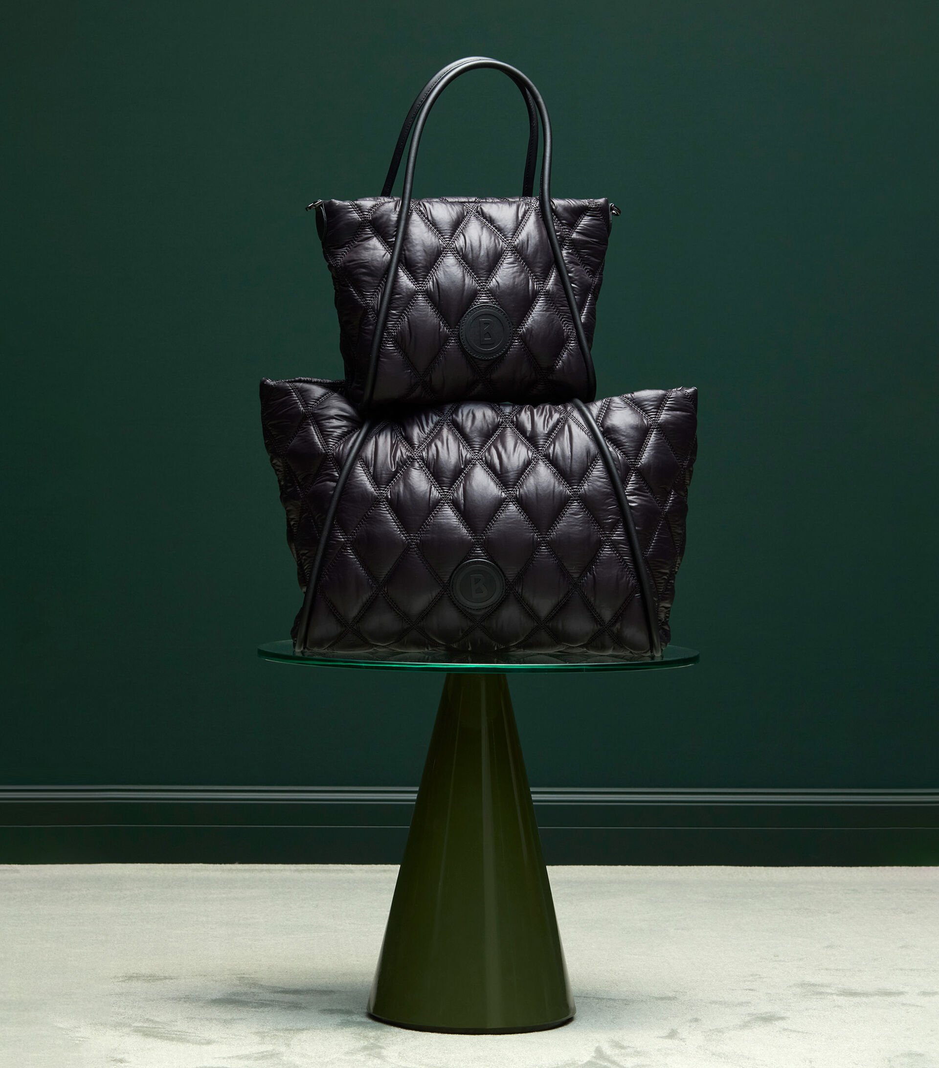 Deux poches matelassées noires superposées dont la forme rappelle un sapin de Noël.