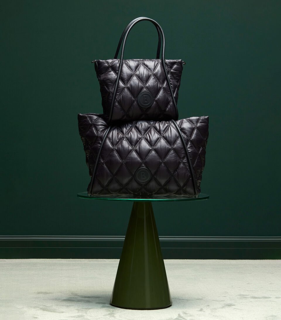 Deux poches matelassées noires superposées dont la forme rappelle un sapin de Noël.