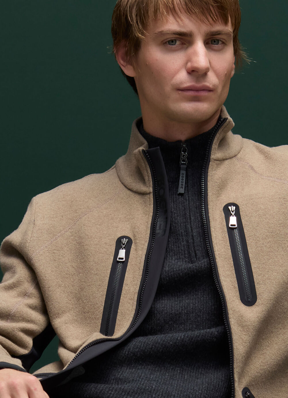 Focus sur le midlayer beige en laine, parfaitement associé à un pull col roulé sombre pour un contraste élégant et contemporain.