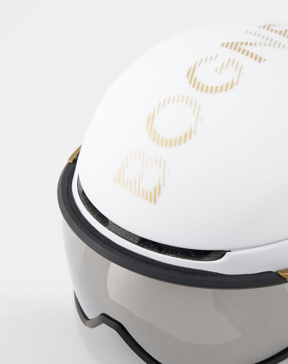 St. Moritz ski helmet in white with gold-tone lettering. Features an integrated coated multilayer visor.