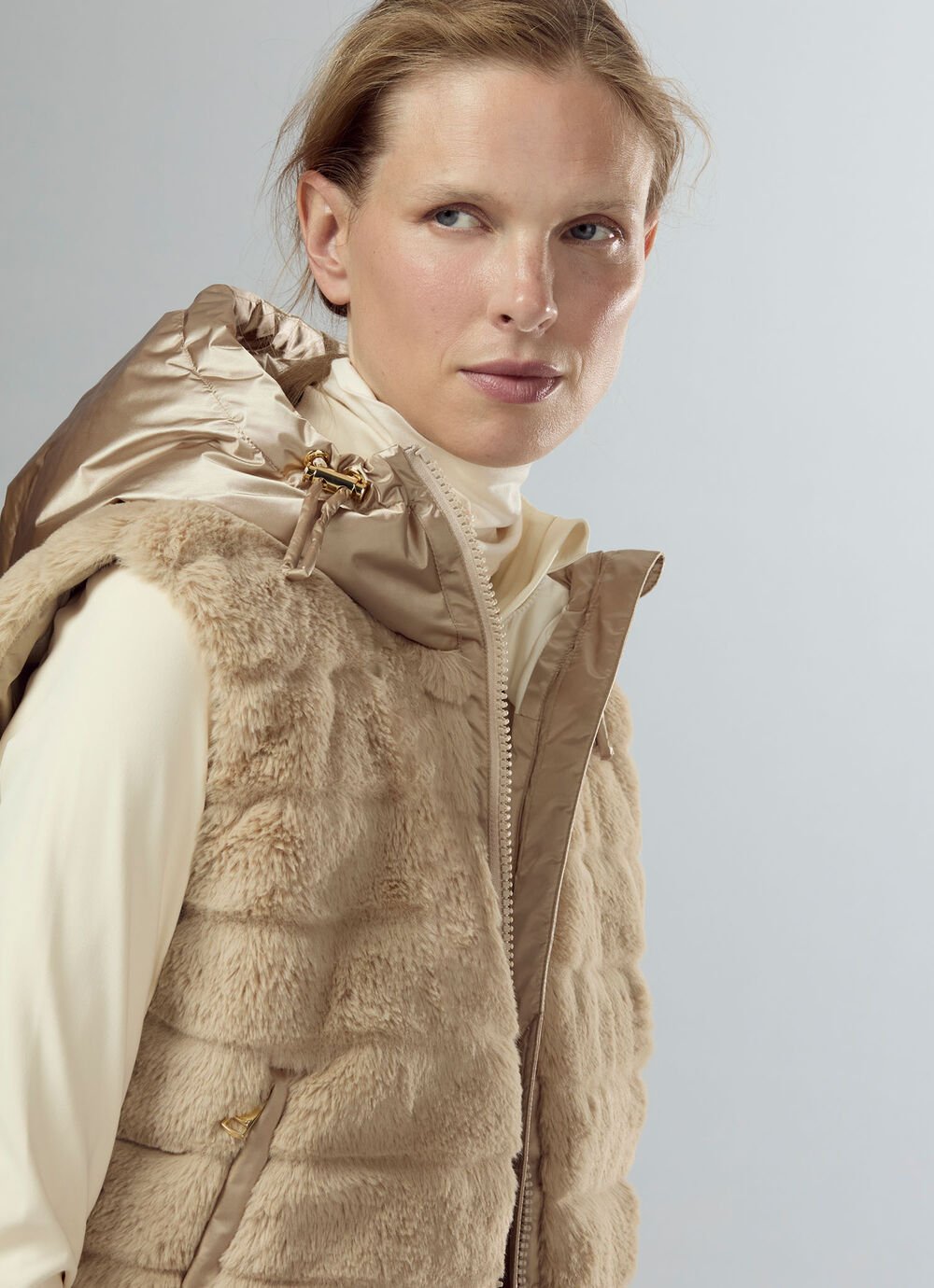 Weste Yumi aus Faux Fur und Satin wird am Damen Model in einem Close-up mit einem Rollkragenshirt gezeigt.