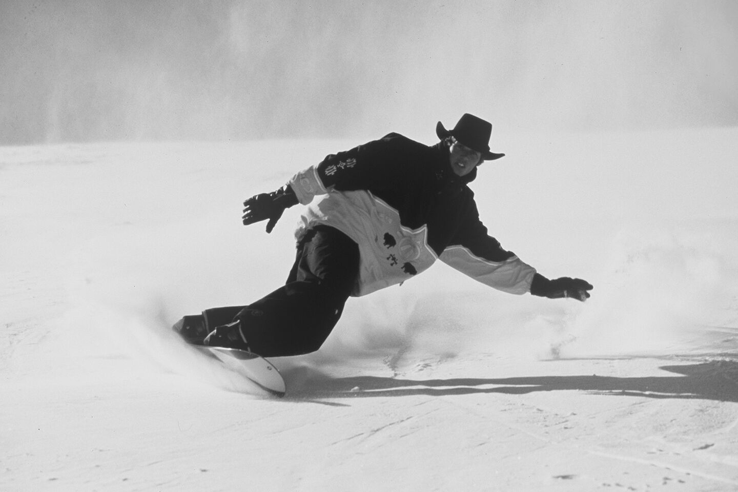 Ein Schwarz-Weiß-Bild eines Skifahrers, der die Piste runterfährt.