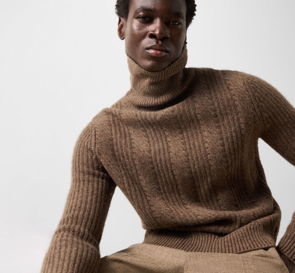 The male model wears the Eros yak sweater in brown with the Marcus virgin wool-blend trousers.