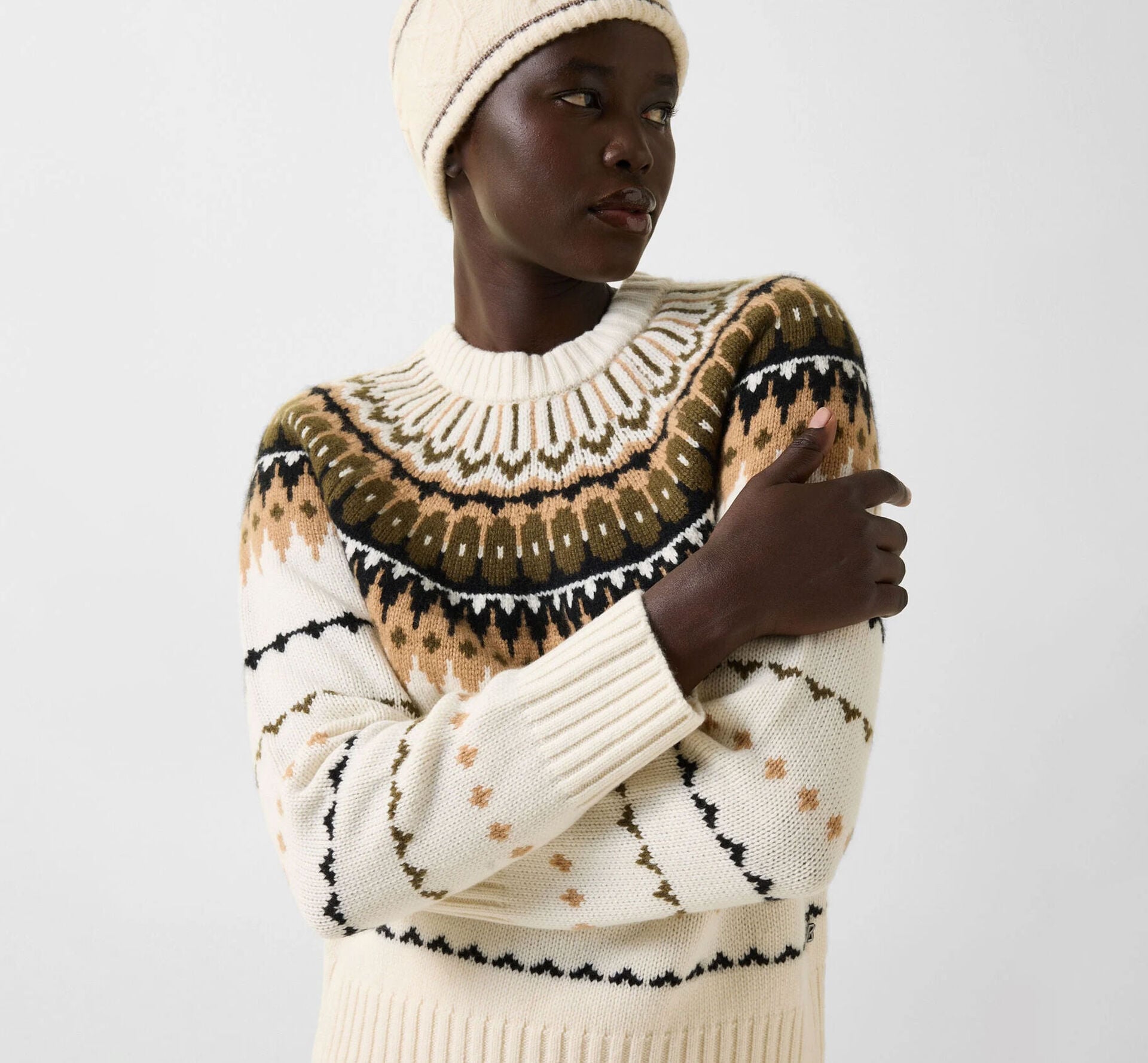 The model is wearing the Ina sweater in soft pure cashmere, accented by a brown Nordic-inspired pattern.
