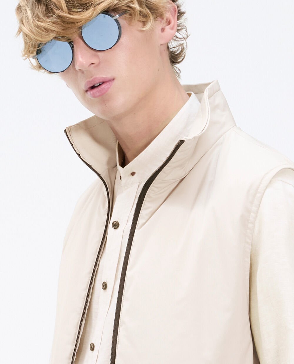 The male model wears round sunglasses with polarised lenses.
