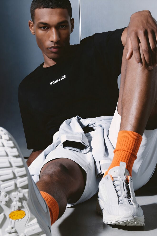 Close-up der FIRE+ICE Montana Sneaker in Grau, die vom Herren Model getragen werden. Er sitzt in l&auml;ssiger Pose auf dem Boden.