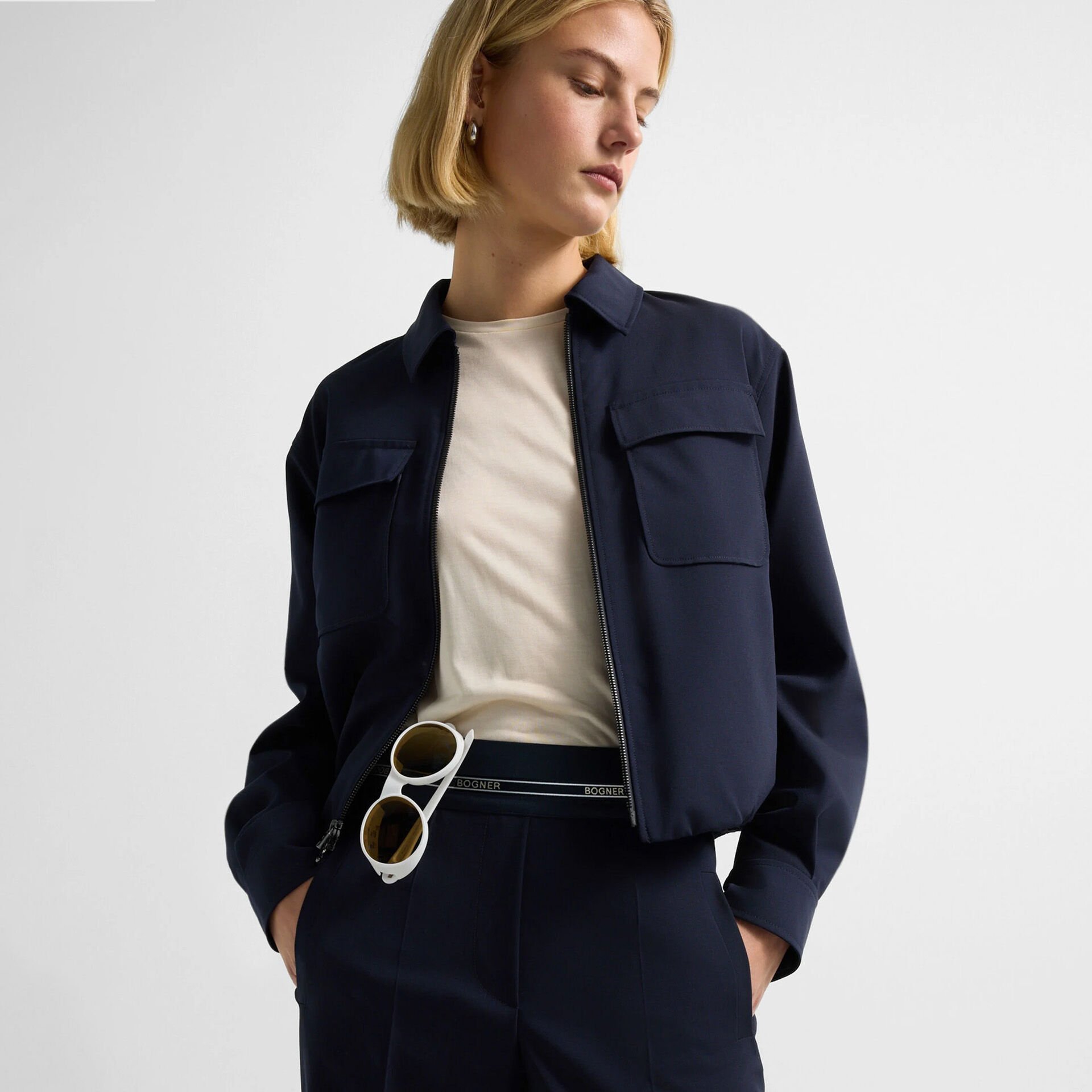 Close-up des Damen Models mit Hemdjacke Tracy in Navy-Blau. Sie tr&auml;gt eine dazu passende Hose mit Logo-Borte.