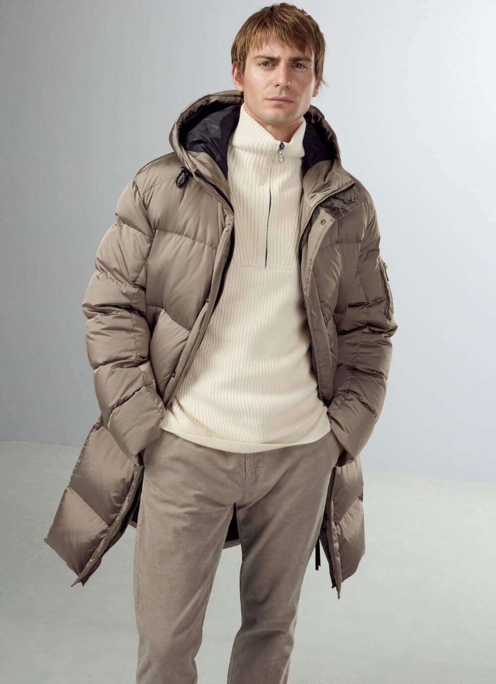 The Erico down coat in greige is paired here with a cream-coloured cashmere Troyer and matching trousers.