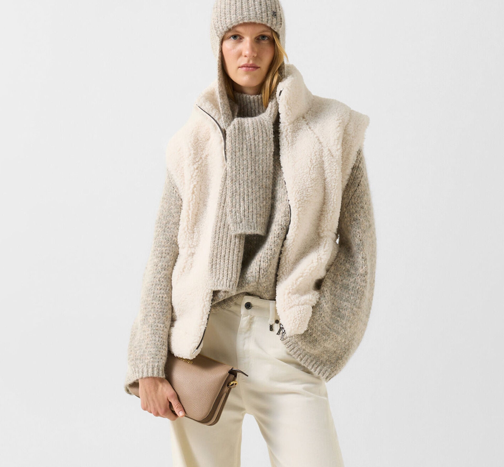 Das Model tr&auml;gt den weichen Svoni Pullover kombiniert mit einer Weste und der Schalm&uuml;tze Suzanne.