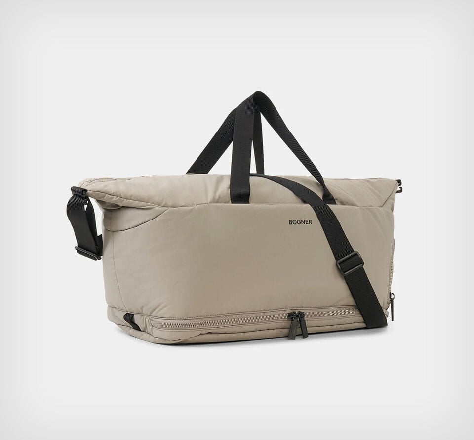 This photo shows the Bromont Dearden weekender bag in taupe with a detachable shoulder strap and a handle.