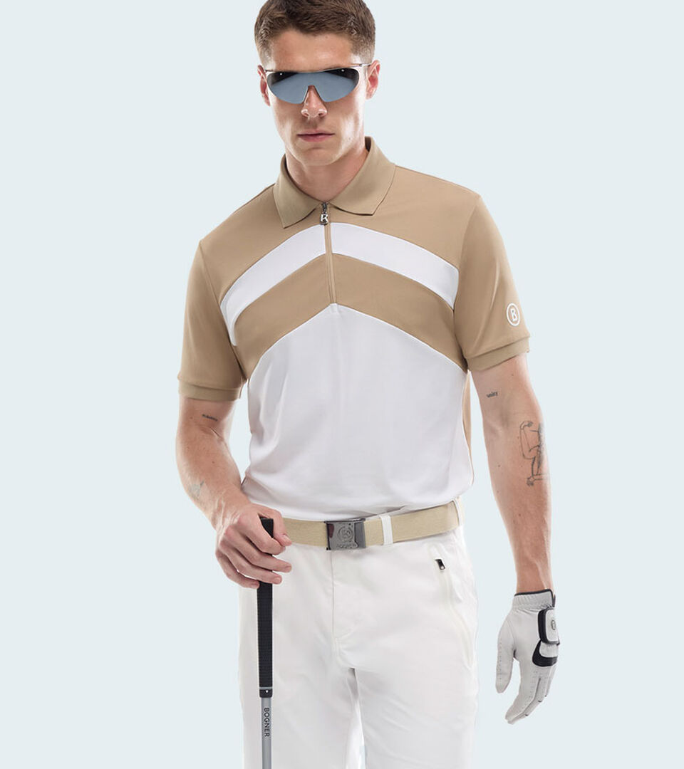 The male model is wearing a polo shirt with a short zip and a white and beige-coloured &lsquo;W&rsquo; motif, paired with white trousers and a belt.