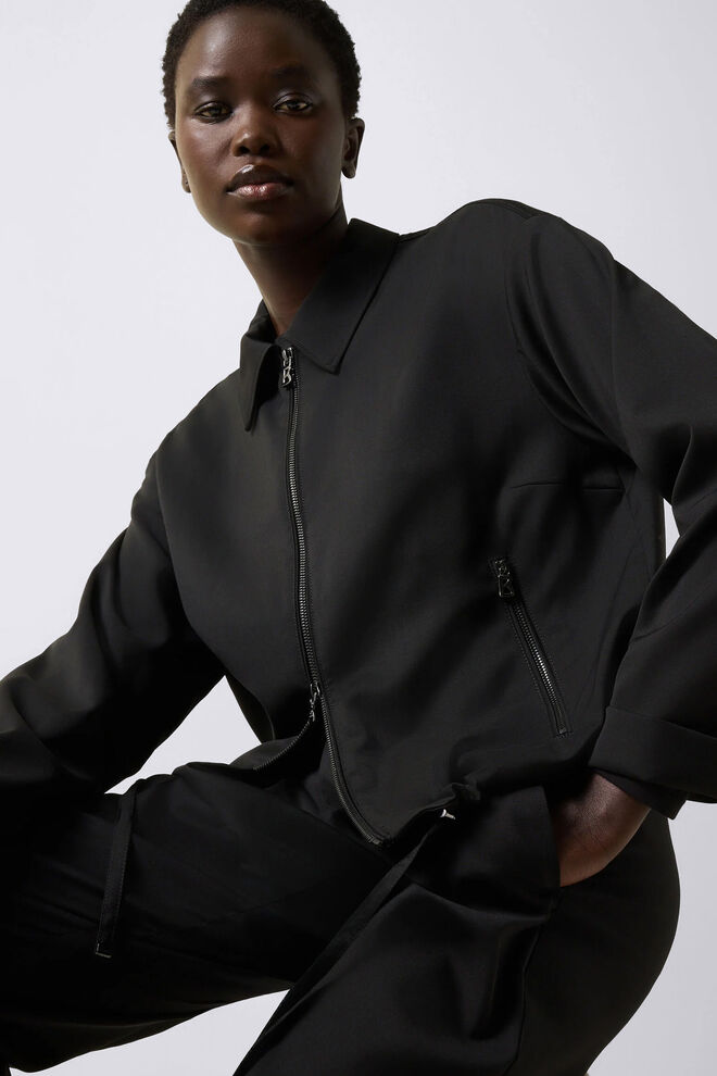 The model is wearing the Elody blouse combined with Elfy trousers made of pure Italian virgin wool.