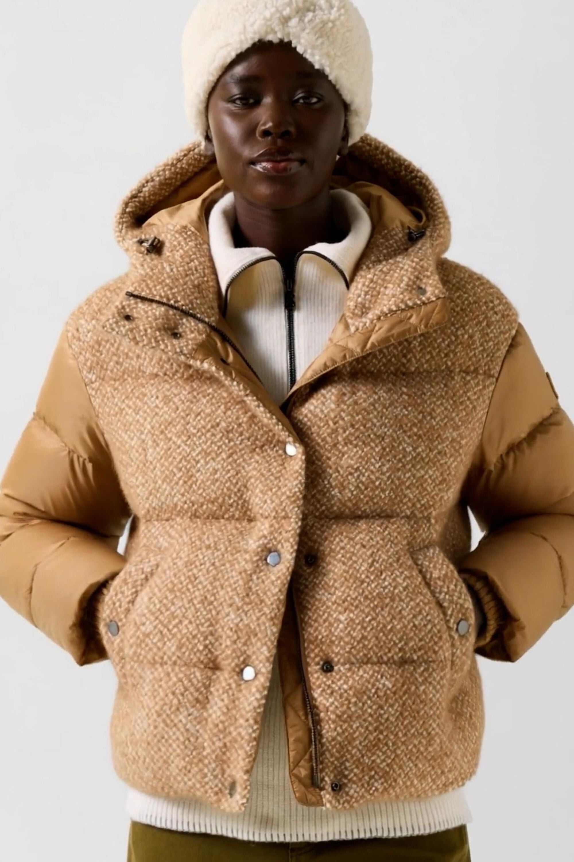 The female model wears the Cathy boucl&eacute; down jacket in Camel, paired with the Justy teddy headband in cream.