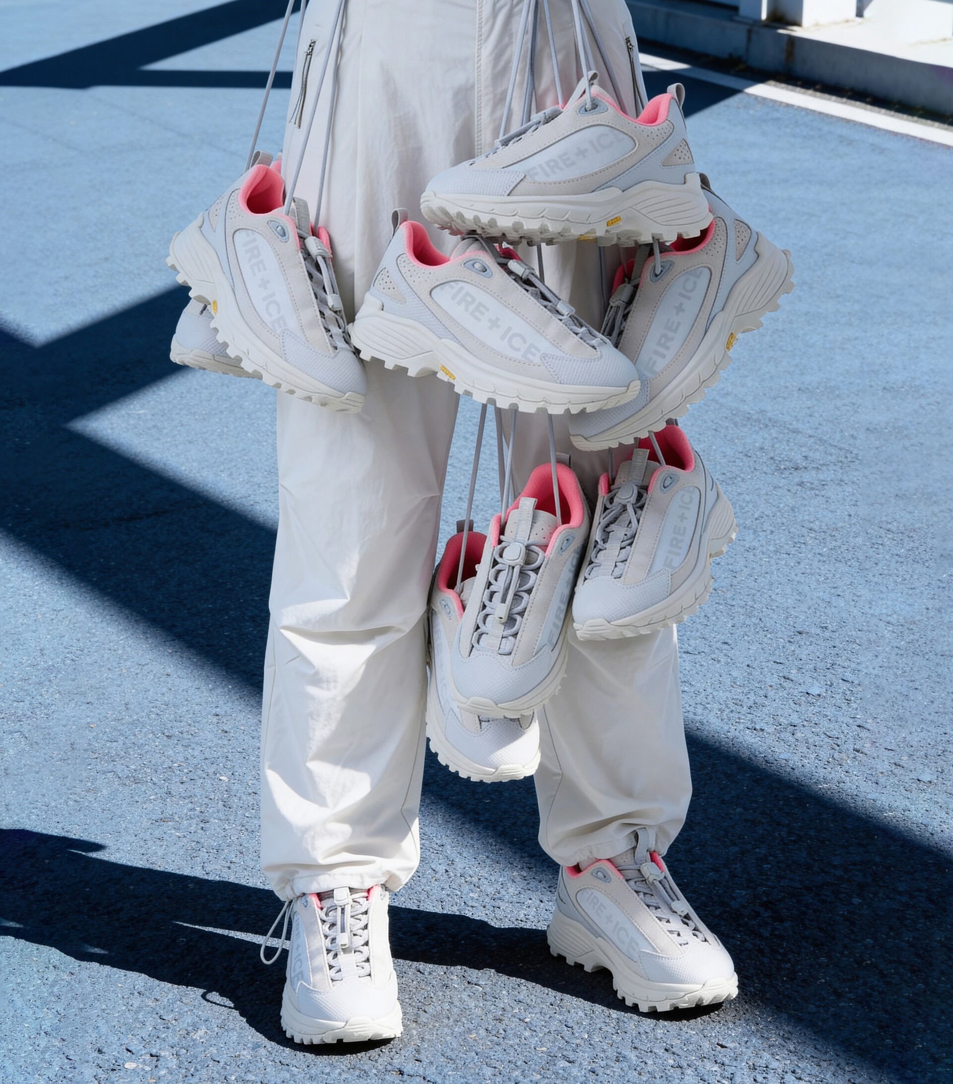 The female model is seen holding a range of Montana trainers in grey and pink in her hand.