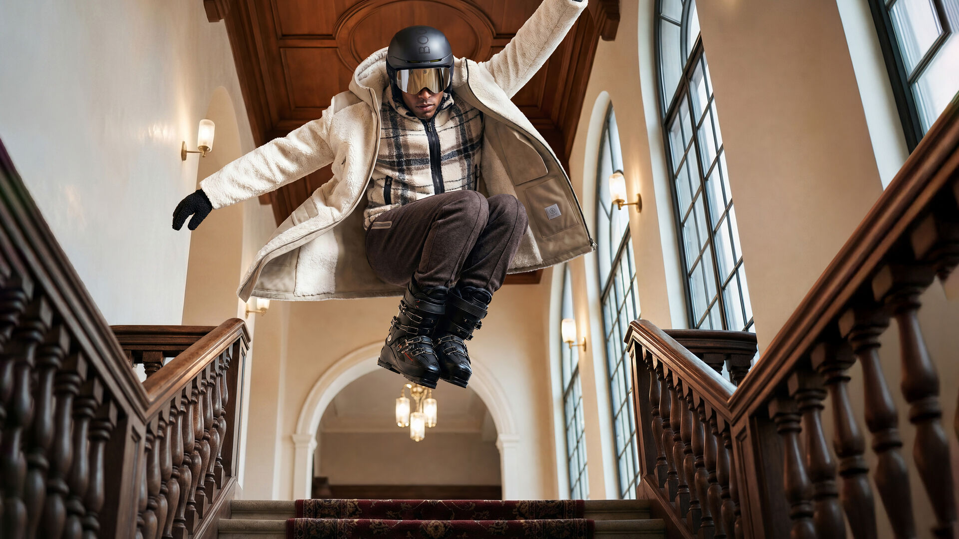 The model in a dynamic pose wears the Soan coat layered over the checked Kristian mid-layer.