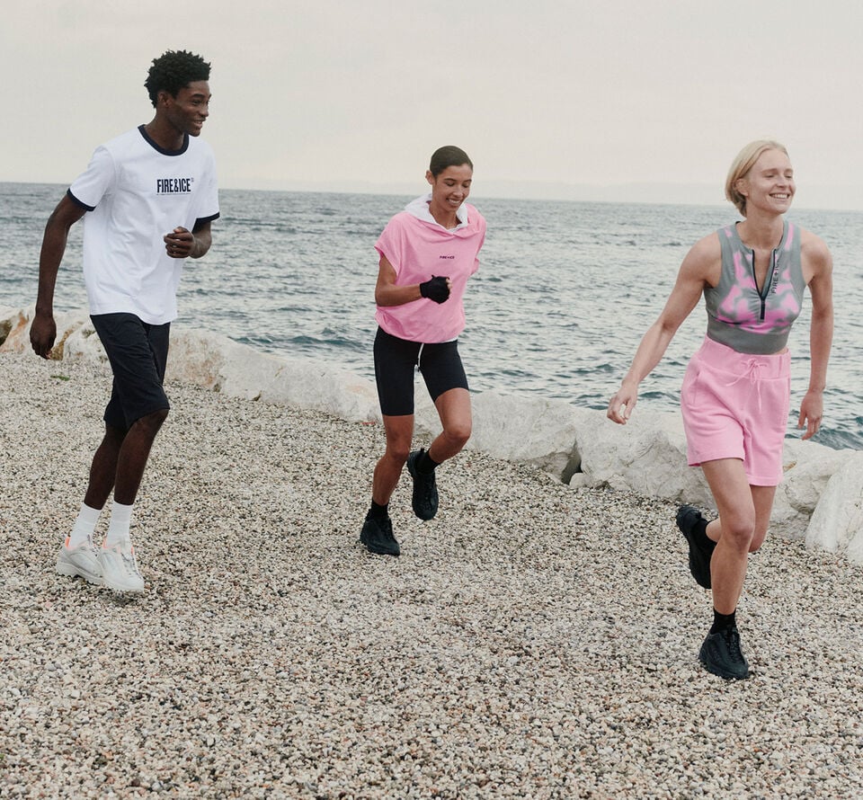 The three models wearing lightweight FIRE+ICE summer looks in white, pink and black are running along the beach.