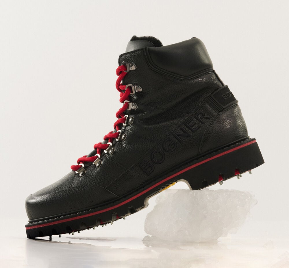 Black winter boots with fold-out spikes in black, with logo details and contrasting red laces.
