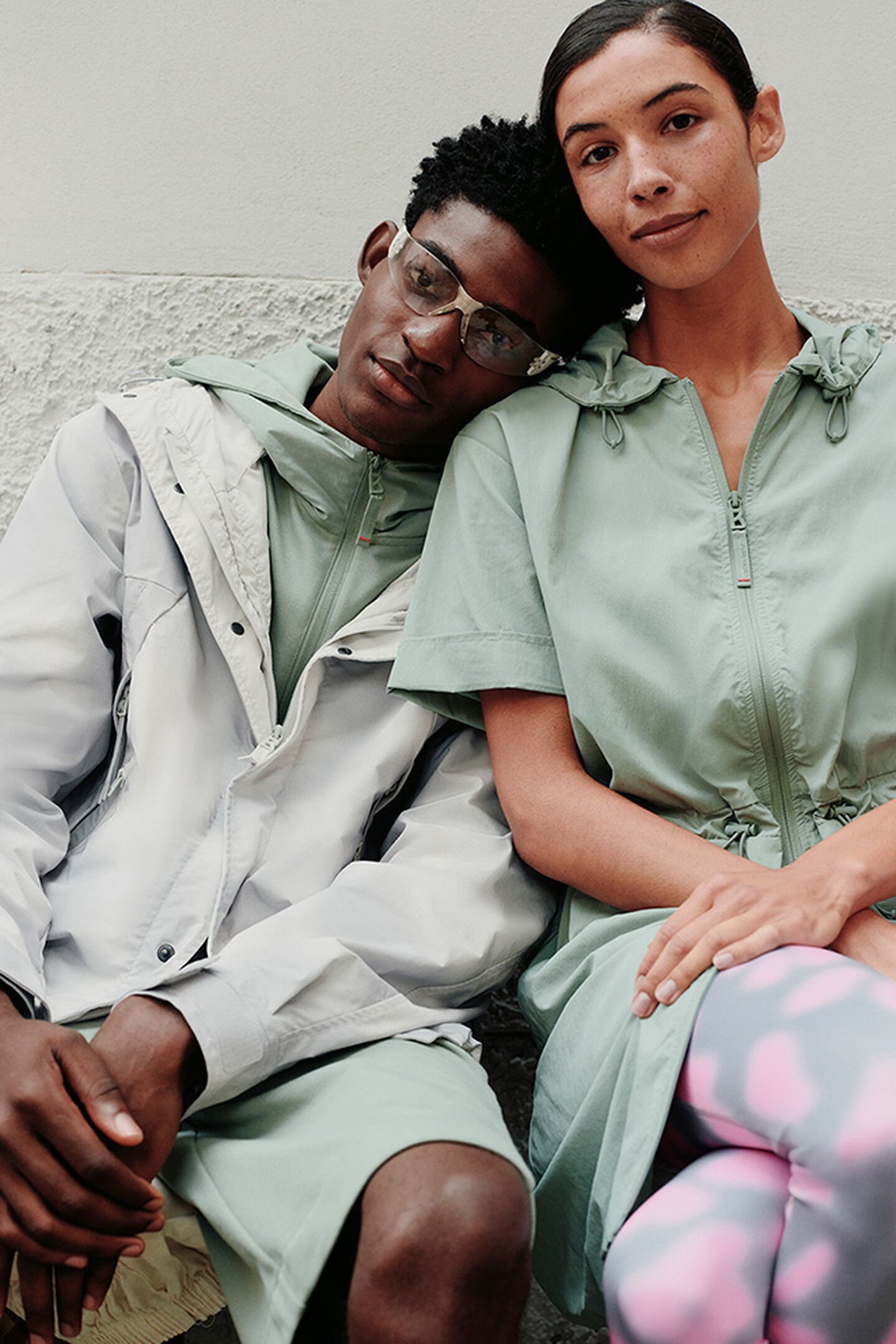 Half-body shot of a seated male and female model. Both in sporty FIRE+ICE looks in green.