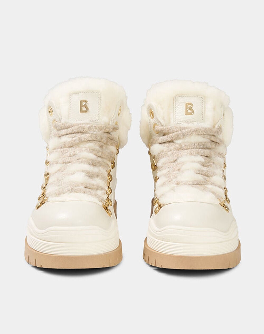 Snow boots in off-white with gold-tone hardware and shearling inserts.