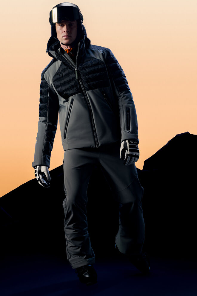 Ganzk&ouml;rperaufnahme des Herren Models vor einer Bergkulisse mit Ski-Daunenjacke Henik in Eukalyptus.