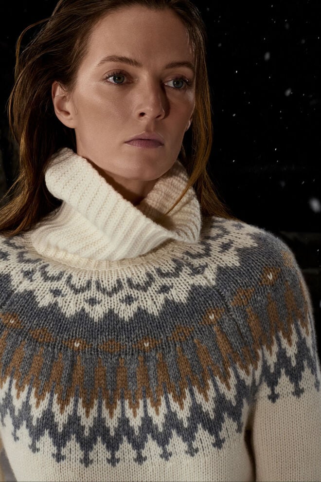 Gehört zu den Key Styles der Damen Kollektion: ein beigefarbener Rollkragenpullover mit grau-braunem Norwegermuster.