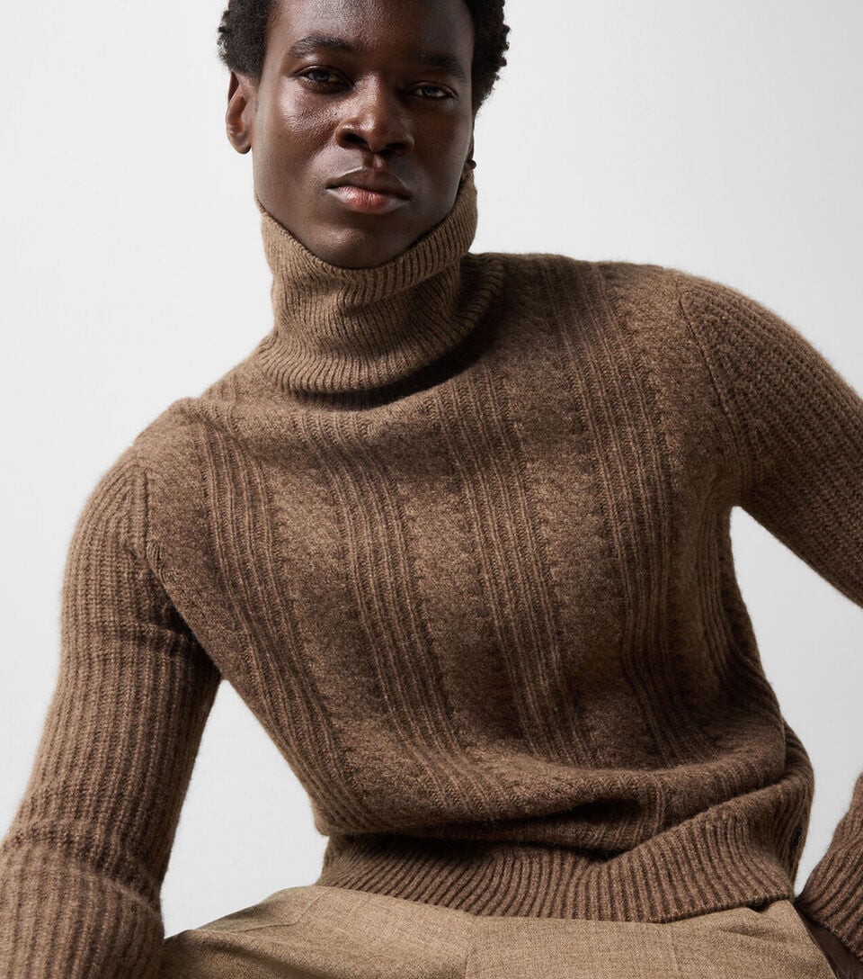 The male model wears the Eros yak sweater in brown with the Marcus virgin wool-blend trousers.