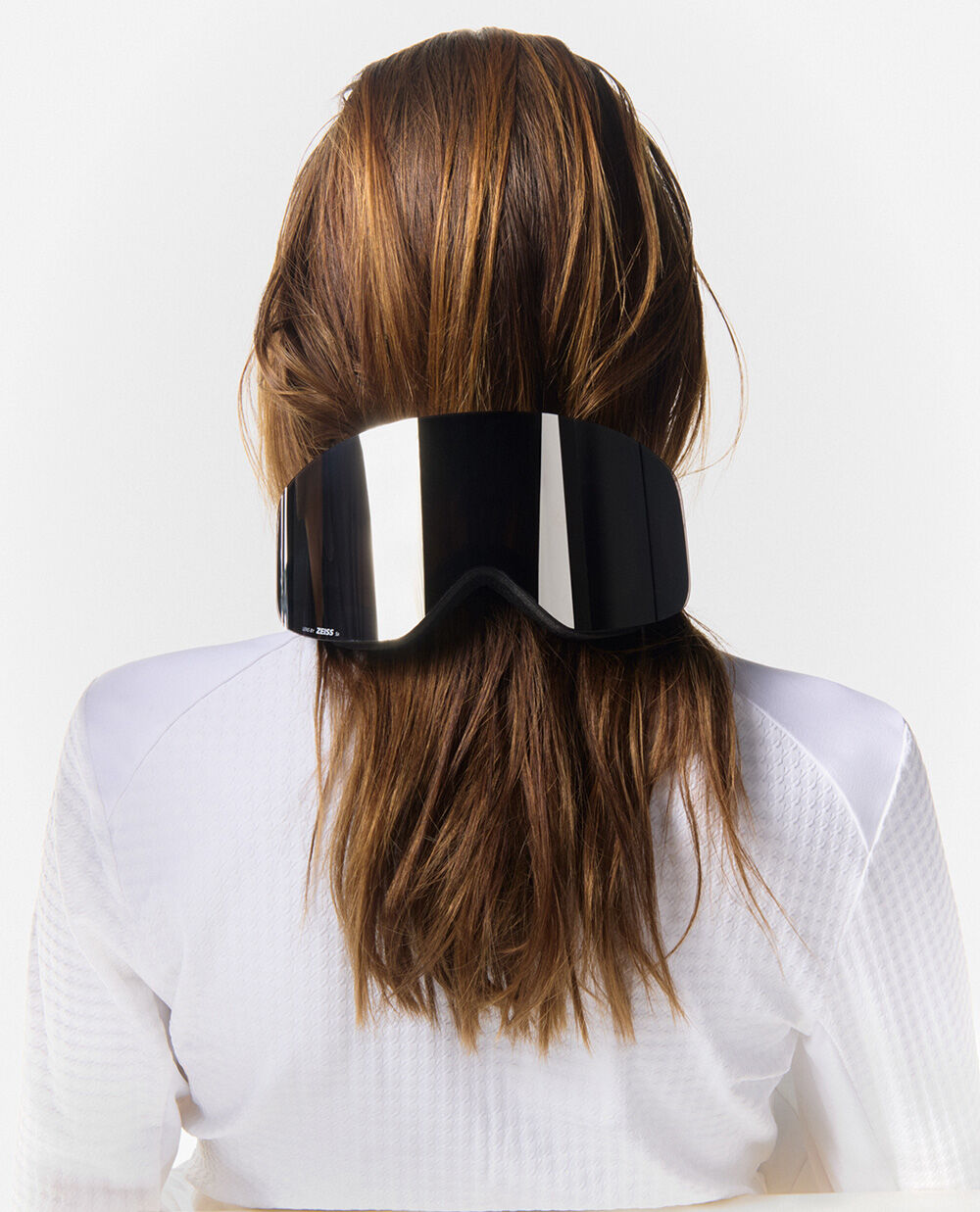 A creative use of the black ski goggles, placed at the back of the long-haired model's head.