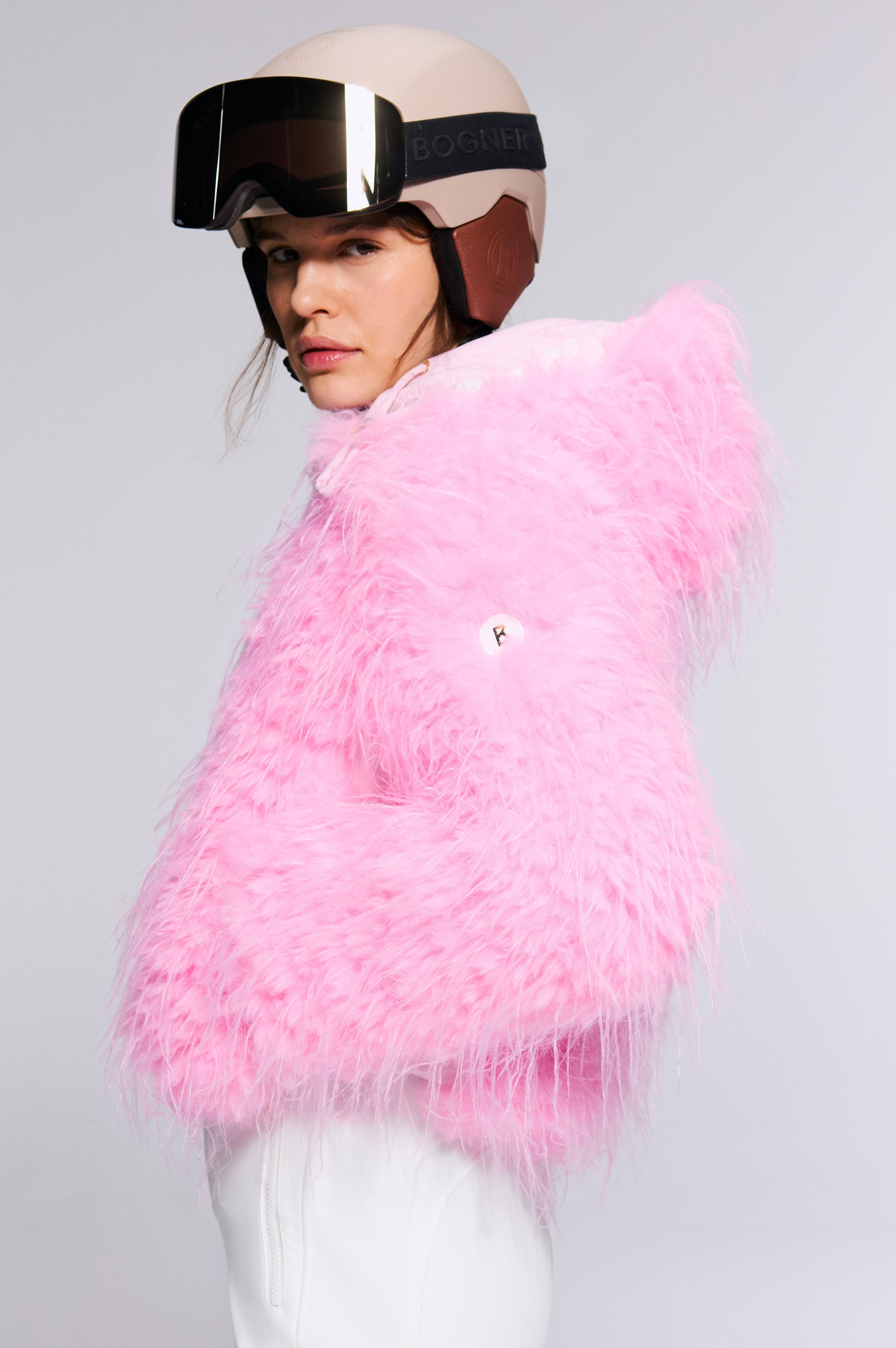 The model combines the pink Kela outdoor jacket with the Cortina ski helmet and the Courchevel ski goggles.