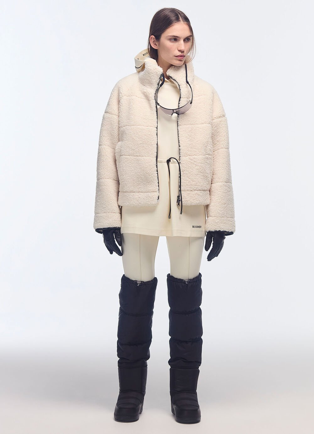 Black quilted over-the-knee boots combined with stirrup trousers, a short skirt, top and fur-trimmed jacket.